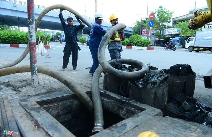 Ông hút được đưa vào sâu bên trong cống để làm sạch bùn. Ở dưới sẽ có người chui sâu vào trong để điều khiển ống hút hiệu quả.