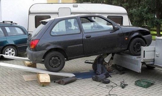 Nguy cơ sập gầm ôtô vô cùng lớn, nhưng để nhanh chóng sửa xong chiếc xe người đàn ông này đã bất chấp tất cả.