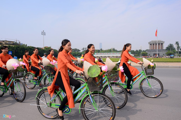 100 nữ sinh với tà áo dài truyền thống đạp xe gắn hoa sen đi qua lăng Chủ tịch Hồ Chí Minh.