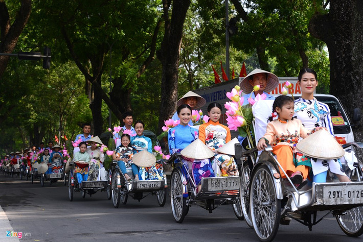 Các thiếu nữ mặc áo dài ngồi trên xích lô đi quanh những con phố thâm nghiêm của Hà Nội.