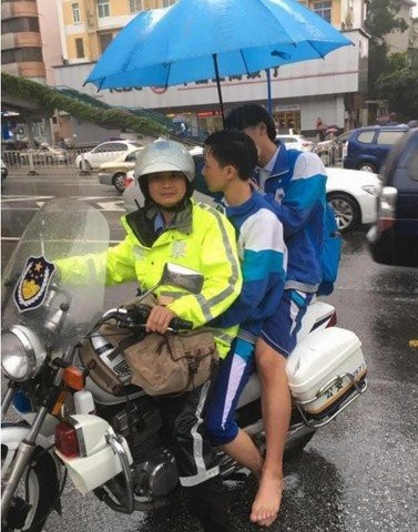 Cảnh sát đưa học sinh tới địa điểm thi vì mưa lụt nặng ở Quảng Châu sáng ngày 8/6.
