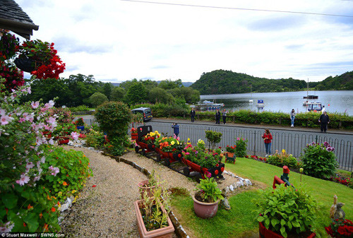 Nhóm khách du lịch đang chụp ảnh khu vườn của ông Robert bên bờ hồ Loch Lomond tại Argyll, Scotland.