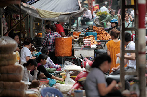 Cảnh buôn bán tấp nập phía sau chợ Đồng Xuân. Toàn bộ hàng hoá của các hộ kinh doanh được bày ngay trên vỉa hè.
