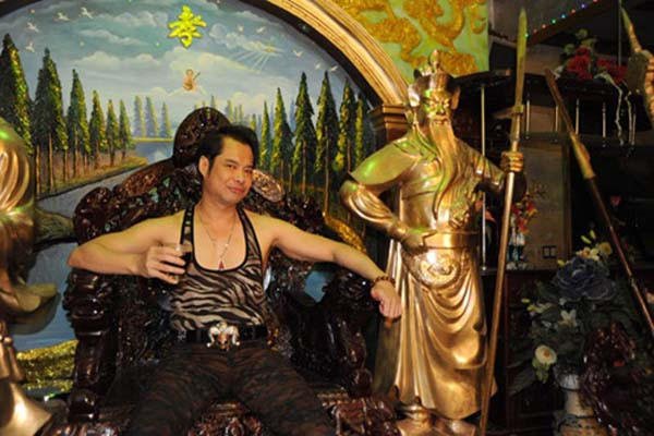 Vua nhạc sến Ngọc Sơn ngồi tạo hình chụp ảnh bên tượng Quan Vũ.
