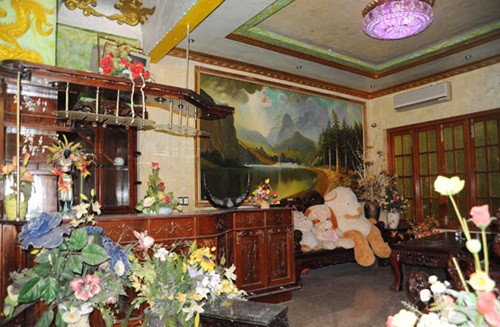 Khu vực quầy bar trong nhà trang trí lòe loẹt như điện thờ với rất nhiều hoa giả.