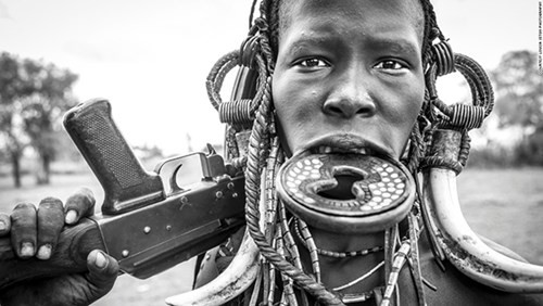 Một người phụ nữ của bộ lạc Mursi với khẩu súng trường AK-47. Trong con mắt của người Mursi, gia súc là tín hiệu đầu tiên của sự giàu có, nên với khẩu AK-47 này, họ sẽ bảo vệ tài sản của mình khỏi những kẻ cướp gia súc.