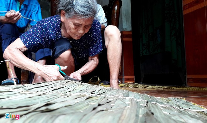 Ngồi bó gối, đôi mắt chăm chú kết hợp với hai bàn tay, cụ bà Trần Thị Minh (80 tuổi) tỉ mẩn thực hiện từng bước làm áo tơi dưới nền nhà. Cụ cho biết, nghề chằm tơi ở Yên Lạc được truyền lại từ thời cha ông đã bao đời nay.