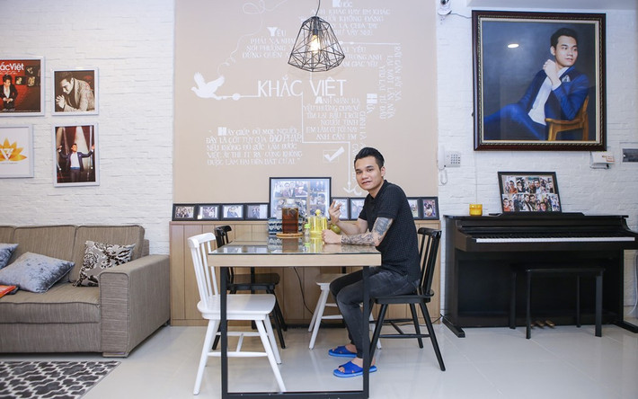 Để tiết kiệm không gian, phòng khách và bàn ăn được thiết kế liền kề nhau. Ở khu vực này, anh đặt họa sĩ vẽ lên tường các ca khúc mình từng thể hiện thành công như một điểm nhấn. Bức tranh chân dung được Khắc Việt yêu thích bởi đường nét tinh tế không khác gì ảnh chụp.