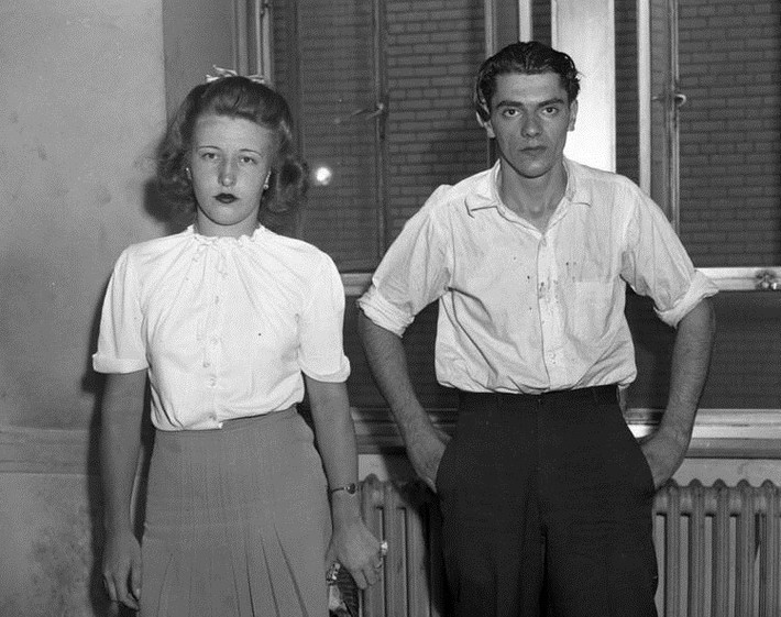 Cô gái 19 tuổi Virgina Ornmark bên cạnh người tình Fred Schmidt, 24 tuổi. Họ nhìn chằm chằm vào ống kính máy ảnh sau khi bị bắt giữ vì tội ám sát ông chủ cửa hàng đồ lót năm 1944. NY Post nhận định: “Ở cạnh một trong những người đàn ông nguy hiểm nhất thế giới khiến những người phụ nữ hoài nghi về hạnh phúc trong tình yêu”.