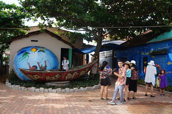 Những chiếc thuyền thúng được sắp xếp bên những bức họa ở làng Bích Họa Tam Thanh rất bắt mắt..Ảnh: Trương Hồng