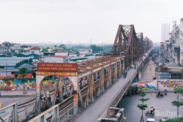 Cầu Long Biên - vẻ đẹp của thời gian bởi màu lịch sử, cái hồn cái tình thắm đượm trong khoảnh khắc của người chụp ảnh. Nhịp sống ven cây cầu Long Biên êm đềm, bình lặng. Đứng ở nơi đây, bạn sẽ có cảm giác như bắt gặp hai cuộc sống trái ngược nhau. Bên dưới gầm cầu là sự tĩnh lặng, bình yên của vùng bãi bồi thôn quê. Phía bên trên là những toà cao ốc, tiếng xe bám rít còi phá bĩnh.