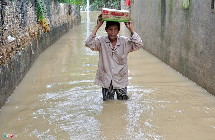 Người dân ở thôn Kim Xuyên (xã Phước Hòa, huyện Tuy Phước) lội bì bõm trong lũ ra tỉnh lộ 636B mua mì tôm ở tiệm tạp hóa về dự trữ trong những ngày ngập kéo dài.