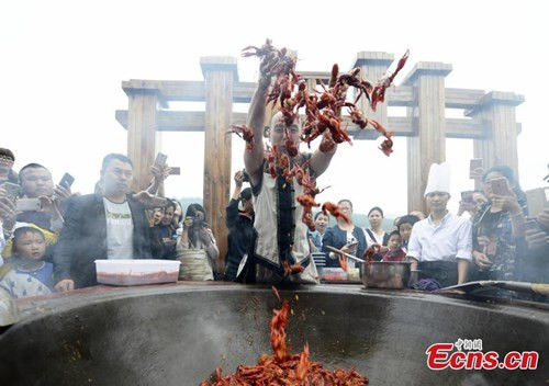 Tại đây, đầu bếp dị nhân Tang Chenggang đã biểu diễn màn xào tôm hùm đất bằng tay trần trong một chiếc chảo gang có đường kính lên tới 2m.