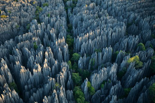 Rừng núi đá ở Madagascar Những mỏm đá và hẻm núi sắc lẹm, tưởng như có thể xuyên thủng cả bầu trời xanh trong phía trên là đặc sản của rừng núi đá tại Cộng hòa Madagascar, châu Phi. Chúng được hình thành qua hàng triêu năm và các hang động hẹp nằm sâu dưới lòng đất, nơi sâu nhất là 120m. Những cơn mưa gió mùa đã làm xói mòn lớp đá vôi dày và trầm tích từ kỷ Phấn Trắng, từ đó tạo thành một trong những kỳ quan thiên nhiên độc đáo và cũng bí ẩn bậc nhất thế giới với con người.