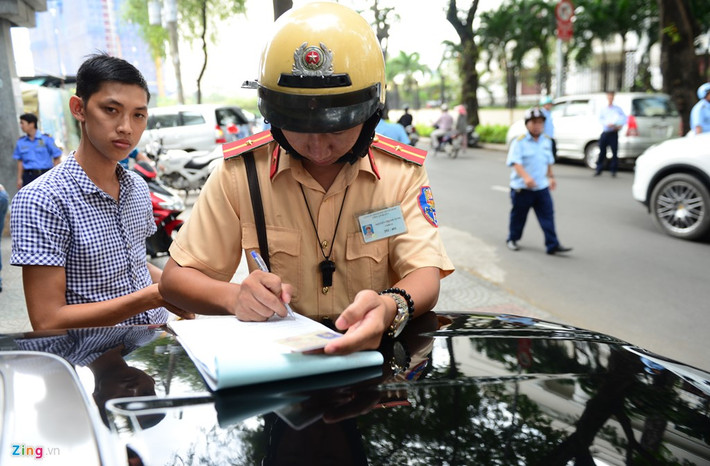 CSGT đang tiến hành lập biên bản xử phạt người điều khiển phương tiện đậu xe lấn chiếm vỉa hè.
