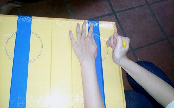 Bước 2: Dùng dao rạch giấy cắt theo đường viền hình tròn đã vẽ trên thùng xốp, làm tương tự cho bên còn lại.
