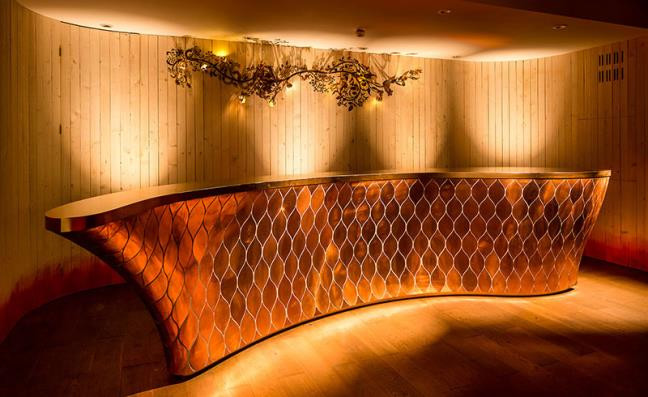Cũng giống hình dạng như các quầy bar khác, tuy nhiên đây không phải là một quầy bar gỗ hay bê tông mà nó làm hoàn bằng chất liệu kim loại đồng màu.
