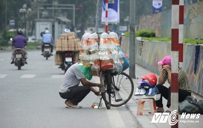 Để tiết kiệm diện tích, chỉ cần một chiếc ghế để bày bán mũ bảo hiểm. Tại Hà Nội, những "cửa hàng" mũ bảo hiểm như vậy rất dễ bắt gặp trên các con phố. (Ảnh: Tùng Lâm)