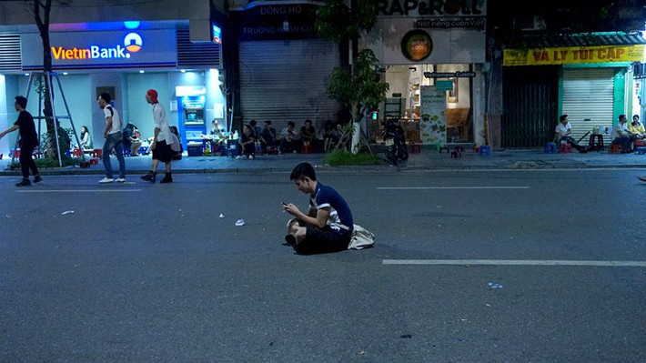Không thiếu chỗ ngồi nghỉ trên vỉa hè, nhưng nhiều thanh niên chỉ thích ngồi giữa lòng đường làm việc riêng.