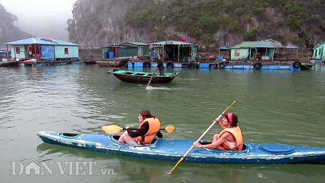 Du khách nước ngoài tự mình chèo thuyền kayak để khám phá làng chài cổ nhất ở Việt Nam.
