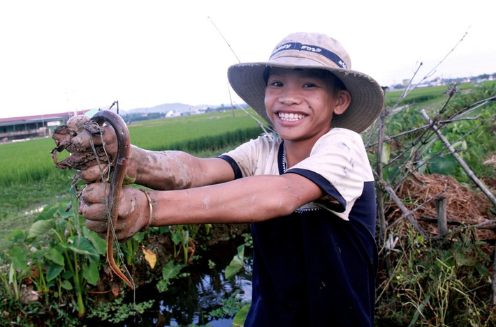 Niềm vui của một thợ nhí 15 tuổi sau khi câu được con lươn khá bự.