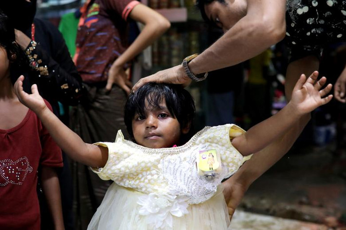 Một bé gái Rohingya thử váy mới trong cửa hàng tại khu trại tị nạn Katupaloong.
