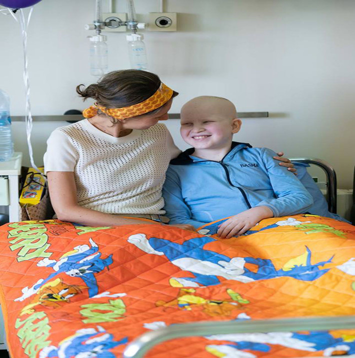 Một em nhỏ cười tươi khi được Đệ nhất phu nhân Asma Al-Assad đến tận giường bệnh thăm hỏi. Ảnh: AMN.