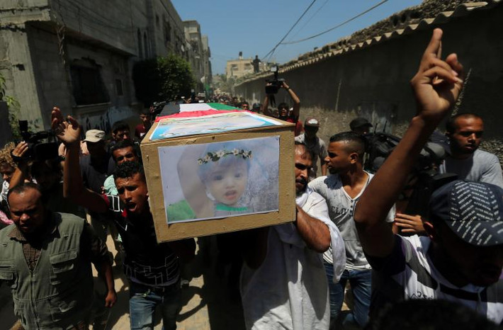 Người dân khiêng quan tài chứa thi thể của Inas Khamash, một phụ nữ Palestine, và đứa con 18 tháng tuổi Bayan của cô, trên đường phố ở trung tâm Dải Gaza ngày 9/8. Ảnh: Reuters.