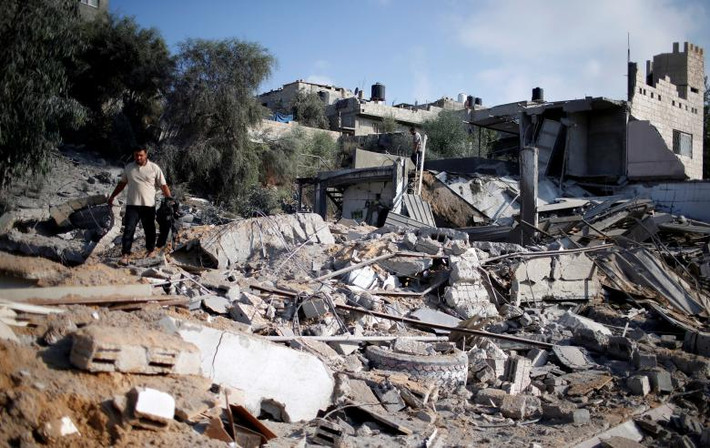 Người đàn ông Palestine kiểm tra một khu vực của Hamas bị trúng bom đạn của Israel tại khu al-Mughraqa ngày 9/8. Ảnh: EPA.