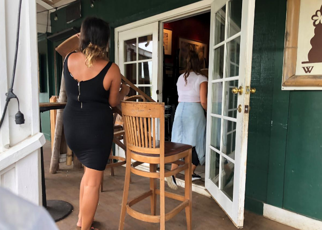 Kelli Berry và Leah Gross di chuyển những chiếc bàn ghế trong nhà hàng Tahiti Nui trước khi tạm đóng cửa nhà hàng này cho tới khi bão Lane đi qua.