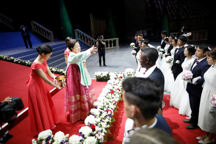 Bà Han Hak-ja, vợ của ông Moon Sun-myung, vẩy nước thánh để cầu phước cho các cặp đôi tại đám cưới tập thể của họ.