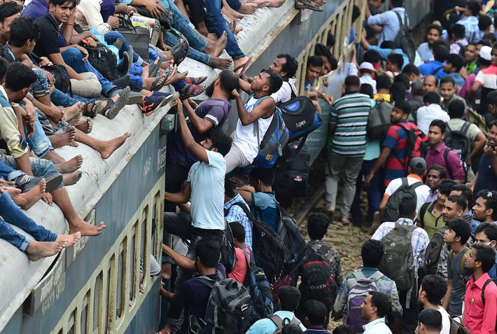 Nhiều người cố leo lên nóc đoàn tàu đã chật kín người tại một nhà ga ở Dhaka.