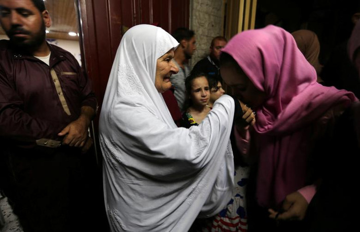 Một bé gái Palestine hôn lên tay của người bà khi bà của cô bé chuẩn bị rời khỏi Gaza để thực hiện cuộc hành hương tới Mecca ngày 3/8.