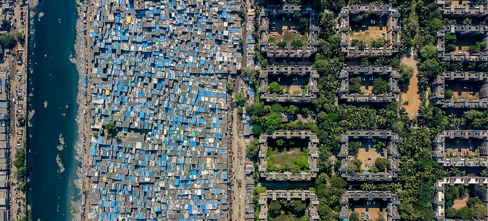 Khoảng cách chênh lệch giàu nghèo cũng được thể hiện rõ ngay trong lòng thành phố Mumbai, Ấn Độ. Bên trái bức hình là khu ổ chuột Dharavi còn bên phải là những tòa nhà dành cho những cư dân giàu có làm việc cho Sàn giao dịch chứng khoán quốc gia và một số công ty lớn nhất Ấn Độ.