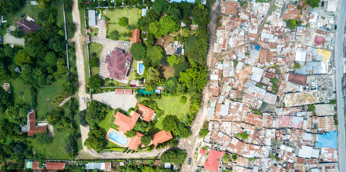 Tại thành phố Dar es Salaam ở Tanzania, năm 2012, Mỹ ước tính khoảng 70% dân số thành phố này sống trong các khu ổ chuột như Msasani (bên phải), nằm ở vùng ngoại ô phía bắc Mikocheni. Bên trái bức hình là những biệt thự của giới nhà giàu.