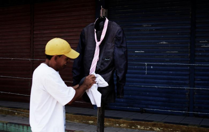 Một người đàn ông Venezuela bán cà vạt và chiếc áo jacket trên đường phố ở bang Roraime, Brazil.