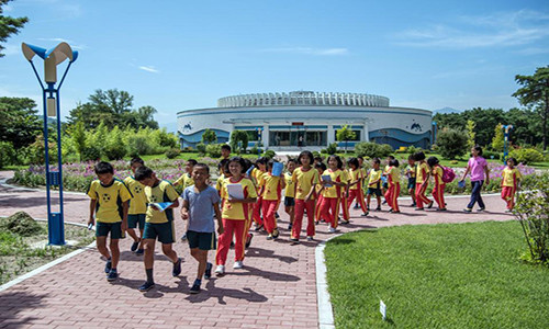 Các em học sinh đi bộ qua trại hè quốc tế Songdowon.