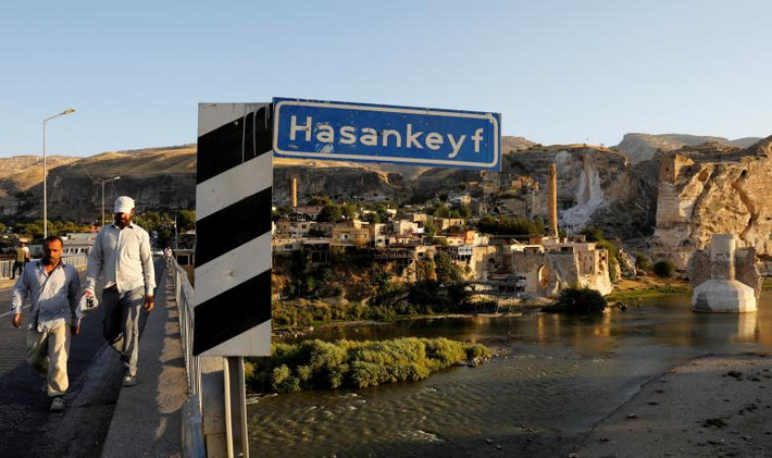 Người dân đi qua một cây cầu bắc qua sông Tigris tại thị trấn cổ Hasankeyf. Phần lớn thị trấn này cùng các khu khảo cổ của nó đang đứng trước nguy cơ bị ngập.