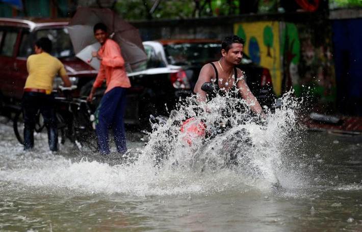 Biển nước mênh mông khiến việc di chuyển của người dân ở Mumbai gặp khó khăn. Ảnh: Reuters.