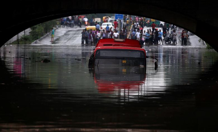 Chiếc xe buýt chìm trong biển nước ở thủ đô New Delhi ngày 3/7. Ảnh: Reuters.