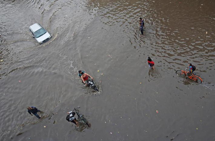 Đường phố biến thành sông ở Ahmedabad hôm 24/6. Ảnh: Reuters.