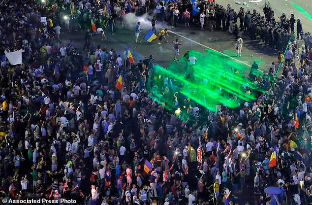 Tờ Daily Mail đưa tin, những người biểu tình ở thủ đô Bucharest đã vẫy cờ Romania, Liên minh Châu Âu, Tây Ban Nha, Italy cùng nhiều quốc gia khác và hô vang khẩu hiệu “Công lý, không tham nhũng” hay “chính phủ hãy từ chức”. Ảnh: AP.