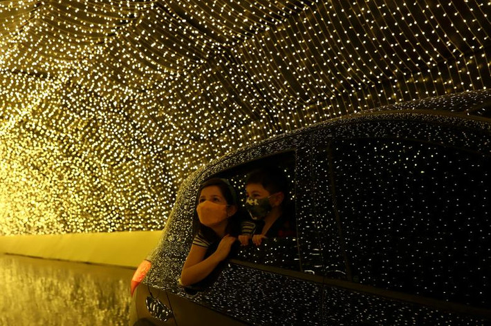 Hai đứa trẻ đeo khẩu trang ngắm nhìn ánh đèn lung linh từ bên trong ô tô khi đến tham quan Luminna Fest - lễ hội ánh sáng Giáng sinh ở Sao Paulo, Brazil, ngày 5/12.