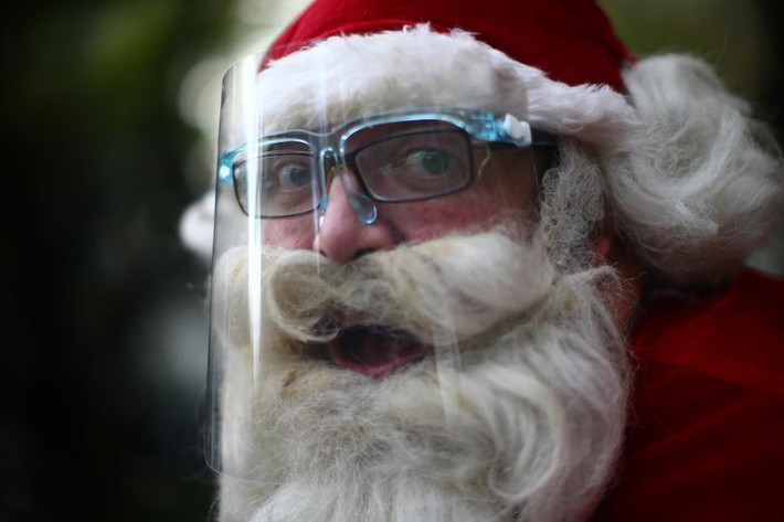 "Ông già Noel" Alejandro Zelayaran, 43 tuổi, đội mũ chống giọt bắn để phòng lây nhiễm COVID-19 khi di chuyển trên đường phố Mexico City, Mexico, ngày 3/12.
