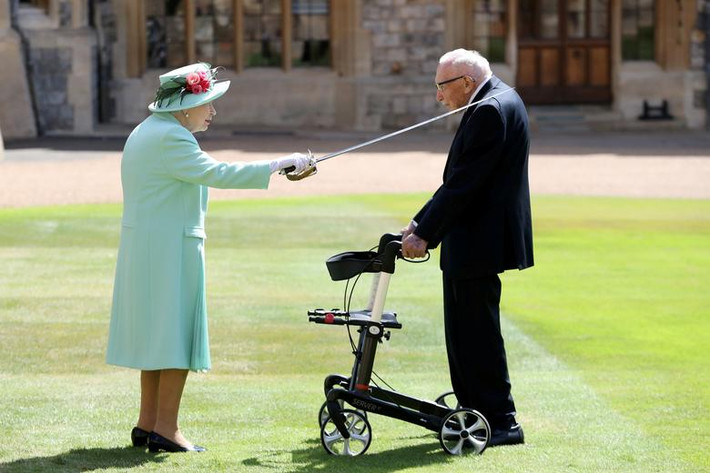 Nữ hoàng Elizabeth II phong tước hiệp sĩ cho cựu binh 100 tuổi Tom Moore tại lâu đài Windsor hồi tháng 7/2020.