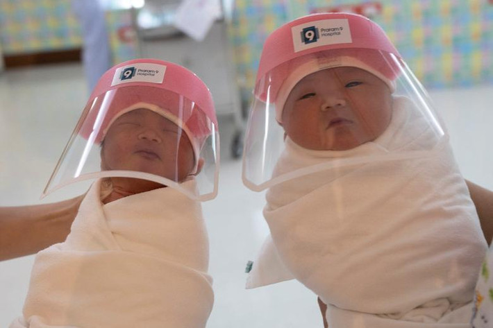Hai em bé sơ sinh được đội mũ chống giọt bắn tại bệnh viện Praram 9 ở Bangkok, Thái Lan, ngày 9/4/2020.