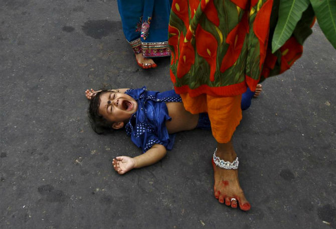 Tín đồ Hindu bước qua người trẻ nhỏ trong một nghi lễ cầu mong phước lành cho đứa trẻ ở Kolkata, Ấn Độ ngày 17/11.