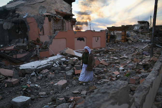 Khalaf Halti, 62 tuổi, thuộc cộng đồng thiểu số Yazidi, đi bộ qua đống đổ nát ở Sinjar ngày 15/11.