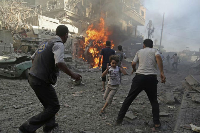 Ranh giới giữa sự sống và cái chết trong thời chiến trở nên thật mong manh đối với trẻ em Syria. Ảnh: Bé trai hoảng hốt chạy loạn sau một vụ tấn công vào Douma, Damascus, Syria ngày 24/8.