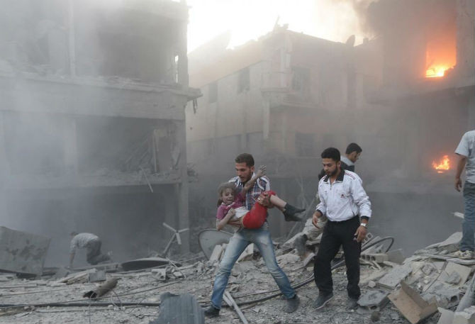 Một cô bé Syria được đưa ra khỏi đống đổ nát ở Douma ngày 16/6.